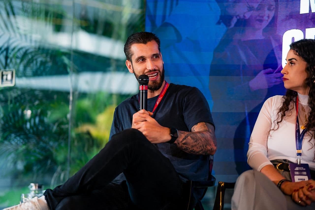 Taillan Moojen falando ao microfone em um evento Mastermind para gestores de academia