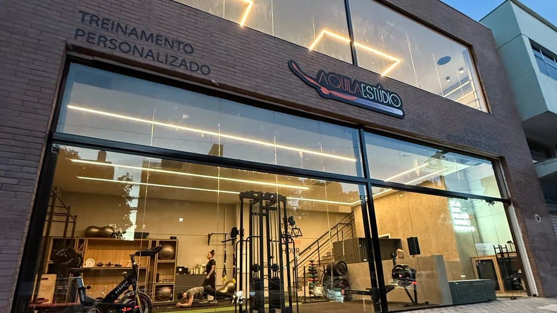 Fachada envidraçada da unidade Aquila Carlos Trein, com o espaço de treino à mostra